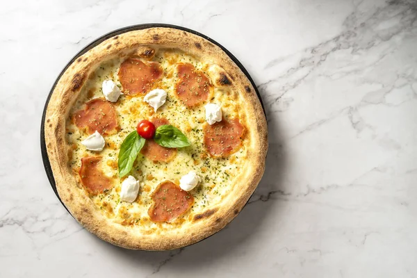 Italian pepperoni and buffalo cheese pizza served on a white marble table. Culinary perfection on display for a tempting feast. High quality photo
