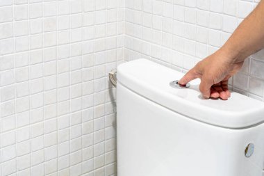 Tuvaletteki su tasarrufu tuşuna basan birinin yakın çekimi. Yüksek kalite fotoğraf