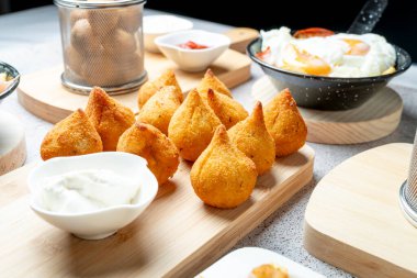 Lezzetli, çıtır çıtır Coxinha, popüler bir Brezilya sokak yemeği, sosla servis ediliyor.