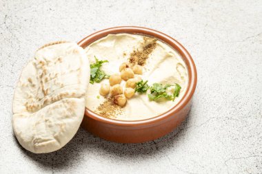 Nohut, maydanoz ve paprikayla kaplı kremalı humus, Pita ekmeğinin yanında servis edilir, çok cazip bir orta doğu aperatifi olur.