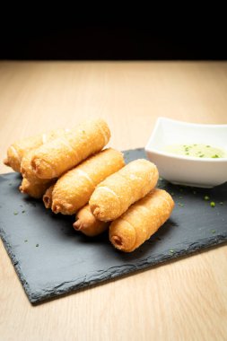 Geleneksel bir Venezuela aperatifi olan guasacaca sosuyla servis edilen lezzetli tekenolar.