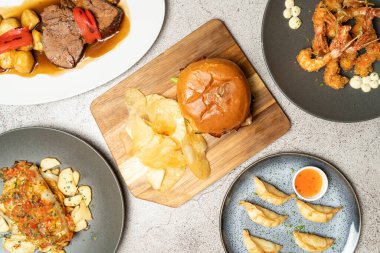 Masada servis edilen çeşitli uluslararası yemeklerin genel görünümü, canlı ve çeşitli mutfak sahneleri yaratıyor.