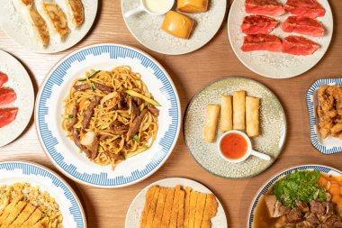 Ahşap bir masaya dizilmiş çeşitli Asya yemeklerinin yukarıdan çekimleri çeşitli mutfak geleneklerini temsil ediyor.