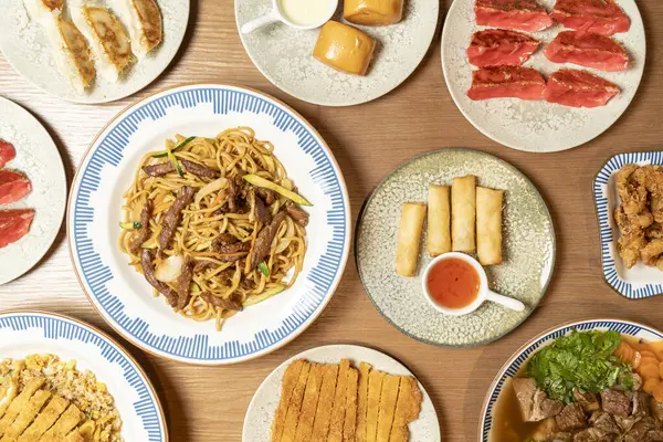 Ahşap bir masaya dizilmiş çeşitli Asya yemeklerinin yukarıdan çekimleri çeşitli mutfak geleneklerini temsil ediyor.