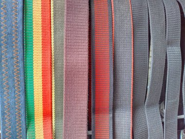 A close-up shot of a collection of colorful and textured webbing straps. The straps vary in width, color, and pattern, showcasing different styles and textures. clipart