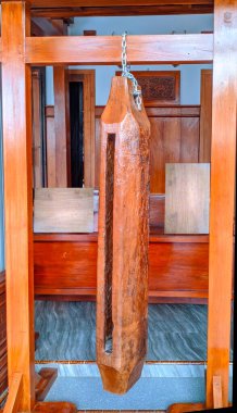 Geleneksel bir Endonezya kentongası, içi boş ahşap bir davul, ahşap bir çerçeve içinde asılı, klasik ahşap mobilya zemin üzerine kurulmuş bir zincir.