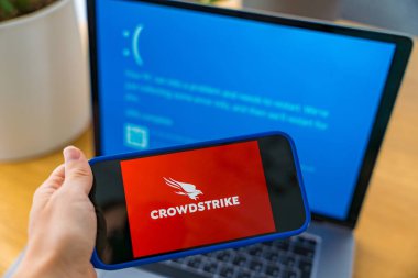 Prag, Çek Cumhuriyeti -13 Eylül 2024: CrowdStrike siber güvenlik yazılımı, Windows hatalı bilgisayar mavisi ölüm ekranının yanında görüntülendi. Dijital koruma ve sorun giderme