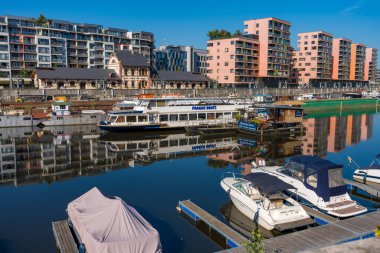 Prag, Çek Cumhuriyeti - 20 Eylül 2024: Selden sonra Holesovice bölgesinde sakin bir manzara, nehir boyunca yanaşan tekneler ve sulara yansıyan modern apartmanlar.