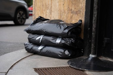 Black sandbags are placed by the entrance of a building in Prague to protect against potential flooding. The scene highlights the precautionary measures taken during the flood threat in autumn. clipart