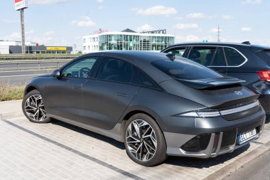 Pruhonice, Çek Cumhuriyeti - 28 Temmuz 2024: Siyah bir Hyundai Ioniq 6 elektrikli araç Çek Cumhuriyeti 'nde bir otoyolun yakınındaki asfalt bir otoparka park edilmiş. Modern EV aerodinamik tasarıma sahiptir.