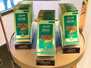 Prag, Çek Cumhuriyeti - 31 Ocak 2025: Lindt Dubai Stili Şam fıstıklı ve kadayif çikolatalarının yakın çekimi, lüks bir mağazadaki altın bir stantta sergilendi. Birinci sınıf İsviçre çikolatası.