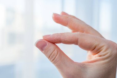 Beyaz bir kadının eli, kışın susuz kaldığı için kurumuş ve çatlamış derisini gösteriyor. Yumuşak doğal ışıklandırma, bulanık arkaplan. Cilt bakımı, cilt bakımı, cilt bakımı ve cilt bakımı.