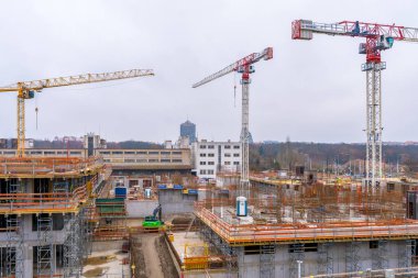 Prag, Çek Cumhuriyeti - 1 Aralık 2024: Bulutlu bir kış gününde, kule vinçleri, iskeleler ve yükselen konut binalarının yer aldığı Zizkov ilçesinde inşaat ilerlemesi .
