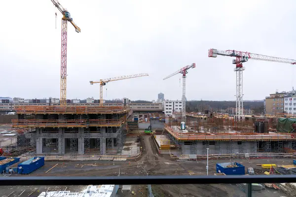 Prag, Çek Cumhuriyeti - 1 Aralık 2024: Bulutlu bir kış gününde, kule vinçleri, iskeleler ve yükselen konut binalarının yer aldığı Zizkov ilçesinde inşaat ilerlemesi.