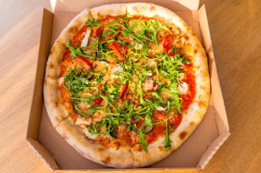 Roka, patlıcan, kırmızı biber, mantar ve peynirli nefis bir pizza. Sıcak ışık, ahşap masa, düz uzanma. Taze vejetaryen fast food. İnsan yok, yemeğe hazır, seçici odaklanma.