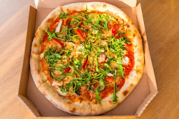 Roka, patlıcan, kırmızı biber, mantar ve peynirli nefis bir pizza. Sıcak ışık, ahşap masa, düz uzanma. Taze vejetaryen fast food. İnsan yok, yemeğe hazır, seçici odaklanma.