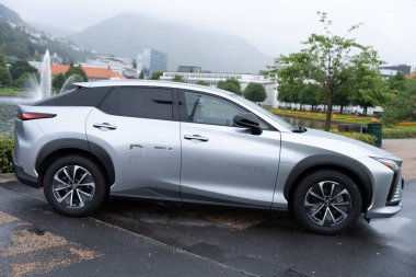 Bergen, Norveç - 7 Temmuz 2024: Lexus Electrified marka elektrikli Lexus RZ 'nin Bergen şehir merkezindeki Lille Lungegardsvannet gölü yakınlarında park edilmiş yan görüntüsü. Kentsel hareketlilik ve yeşil ulaşım.