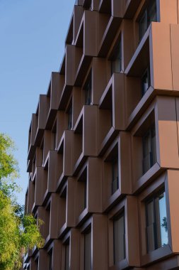 Prag, Çek Cumhuriyeti - 21 Eylül 2024: Karlin ilçesindeki Framnent adlı modern bir konut binasının geometrik cephesi. Açık mavi gökyüzü altında kübik elementlere sahip çağdaş mimari.