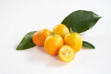 beyaz arkaplanda kumkuat meyveleri