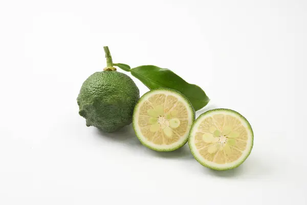    Beyaz arka plana yerleştirilmiş olgunlaşmamış Japon yuzu meyvesi                            