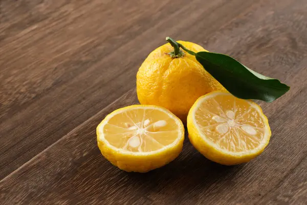 Japon yuzu meyveleri ahşap masaya konur.