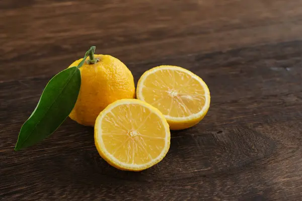 Japon yuzu meyveleri ahşap masaya konur.