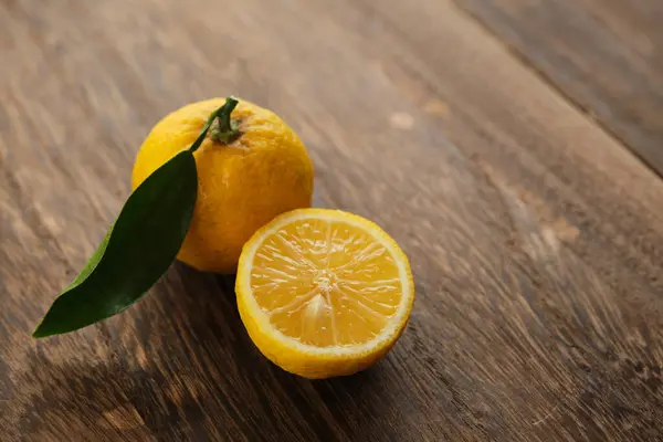 Japon yuzu meyveleri ahşap masaya konur.