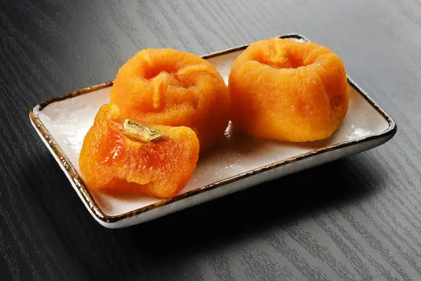 Ahşap zeminde kurutulmuş Japon hurması.