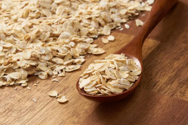 Kırsal bir masada çiğ yulaf taneleri, seçici bir odak noktası.