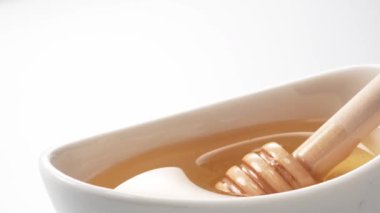 Balın bir bardakta kepçelendiği sahnenin yakın çekimi.