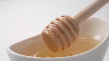 Balın bir bardakta kepçelendiği sahnenin yakın çekimi.