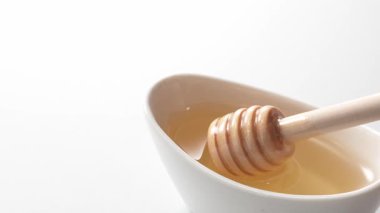 Balın bir bardakta kepçelendiği sahnenin yakın çekimi.