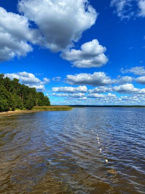 Yazın gökyüzünde bulutlar olan göl
