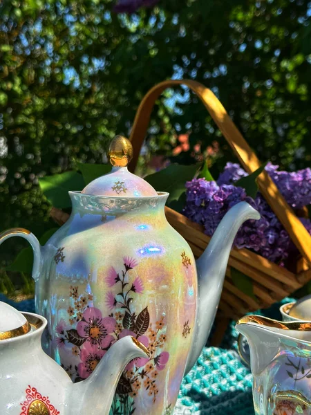 vintage porcelain teapot on the background of flowers