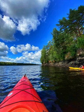 Gölün ortasında, ön planda teknesi olan güzel bir kano resmi.