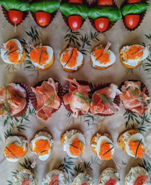 Kırmızı havyar, bıldırcın yumurtası ve jambonlu çeşitli şamdanlar.