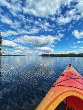 Sakin bir gölde kırmızı bir kano.