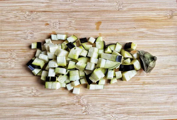 pieces of zucchini on a cutting chopping board on a white wooden table. healthy food.