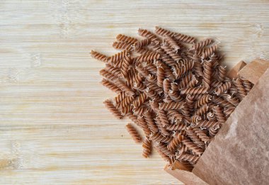 Ahşap arka planda fusilli makarna, bir demet makarna.