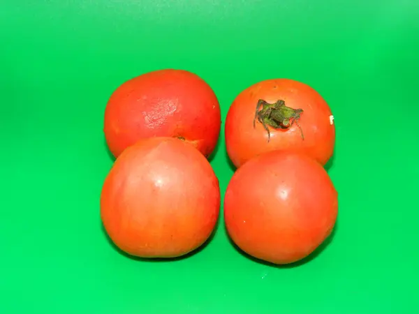 Domates meyvesinin (Solanum lycopersicum) aşırı makro fotoğrafı genellikle yeşil arka plandaki mutfaklarda bulunur. Vit C içerir