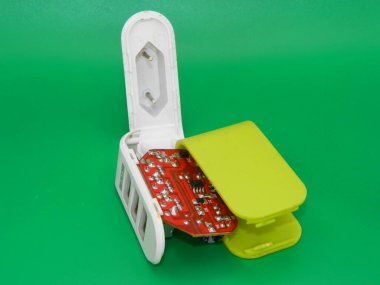 Zarar görmüş bir USB şarj cihazının yeşil arka planlı makro fotoğrafı..