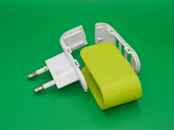 Zarar görmüş bir USB şarj cihazının yeşil arka planlı makro fotoğrafı..