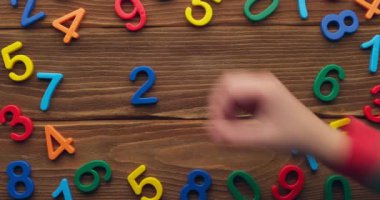 Çocuk eli, 2023 yılını tahta arka plana renkli numaralar koyarak geçirdi. Yüksek kalite 4k görüntü