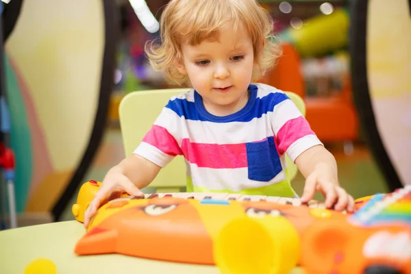 Child playing with colorful toys at the learning center or in kindergarten.