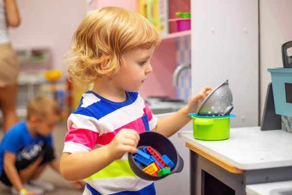 Child playing with colorful toys at the learning center or in kindergarten.