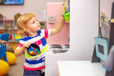 Öğrenim merkezinde ya da anaokulunda renkli oyuncaklarla oynayan çocuk.