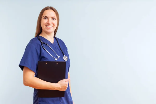 Vrouwelijke Verpleegkundige Arts Met Klembord Tegen Een Blauwe Achtergrond Dokter — Stockfoto
