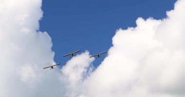 Klasik ışık pervaneli uçaklar beyaz bulutlu güneşli mavi gökyüzünde uçuyor. Yüksek kalite 4k görüntü
