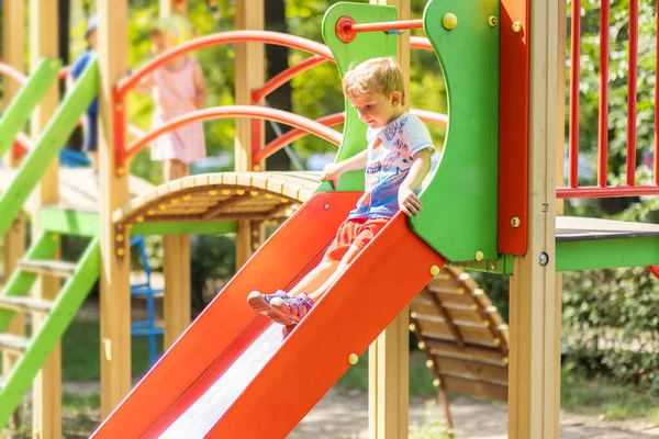 カラフルなスライドでアクティブな子供 屋外遊び場で遊ぶ子供 — ストック写真