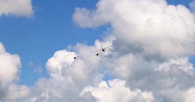 Klasik ışık pervaneli uçaklar beyaz bulutlu güneşli mavi gökyüzünde uçuyor. Yüksek kalite 4k görüntü